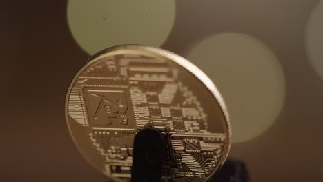 the crypto, bitcoin, spinning around spinning into reflective light.  the future of money.  4k. orange bokeh balls in the background
