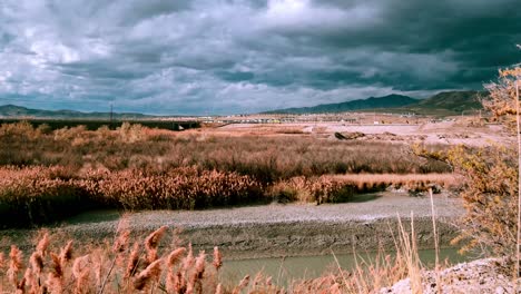 día de tormenta y viento con un espectacular paisaje nublado sobre el río y las montañas - lapso de tiempo estático