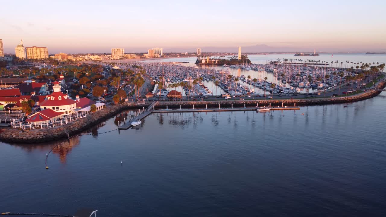 Flygfoto över Shoreline Village i Long Beach, Kalifornien, som visar hamnmarinan, strandpromenader, dockade båtar och det lugna vattnet i Queensway Bay