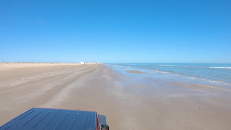 Punto-De-Vista-Del-Techo-Del-Vehículo-Mientras-Se-Conduce-En-Una-Playa-Casi-Desierta-Durante-La-Marea-Baja-En-La-Isla-Del-Padre-Sur,-Texas