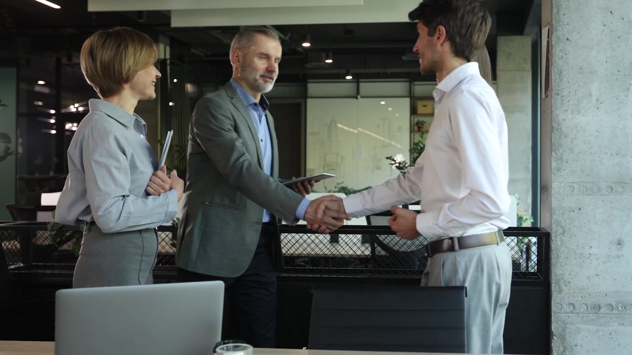 Colleghi che si stringono la mano e discutono in un ufficio moderno