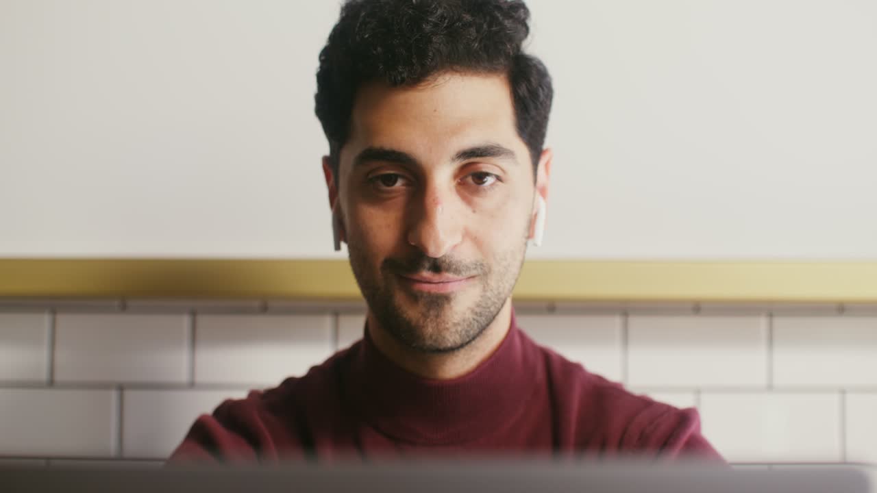 un hombre trabajando en una computadora portátil en un café