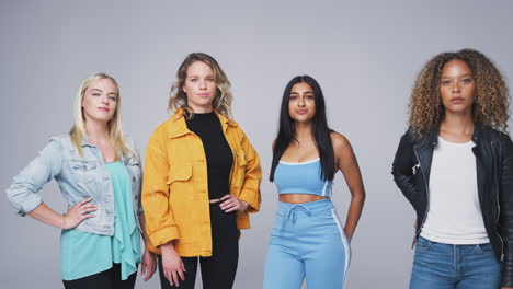 Group-Studio-Portrait-Of-Multi-Cultural-Female-Friends-Going-From-Serious-To-Smiling-Expressions