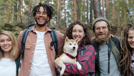 happy friends hiking in the forest with a dog