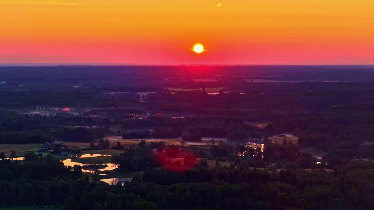 Vibrant countryside landscape at golden hour with sun setting over green fields