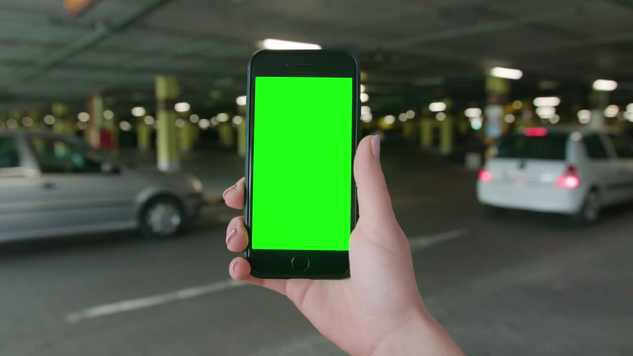 una mano sosteniendo un teléfono con una pantalla verde