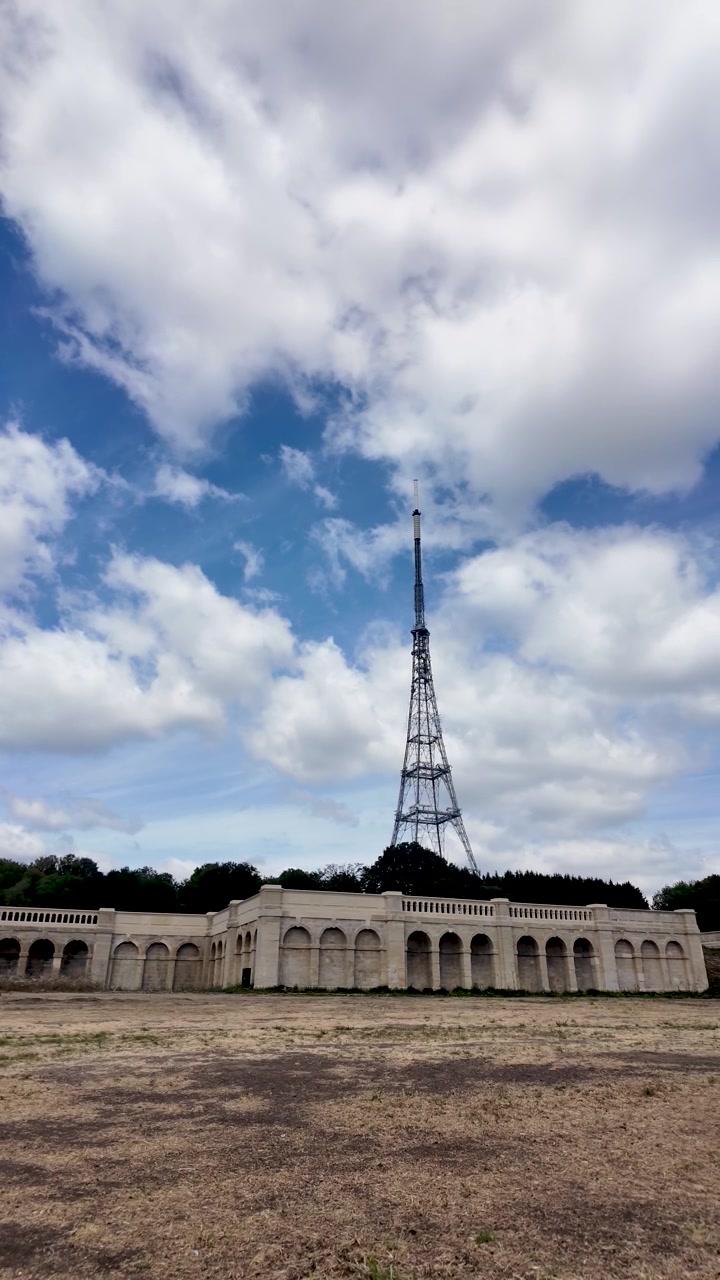 La stazione trasmittente di Crystal Palace si erge sopra le Terrazze Italiane e il prato aperto e secco sotto nuvole estive mutevoli. Video verticale.
