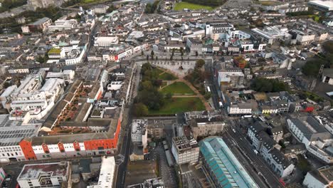 aerial drone tracking shot moving away from eyre square park in galway city