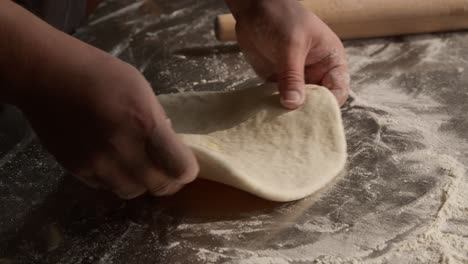 rodando y amasando masa para hornear pan plano, primer plano en las manos