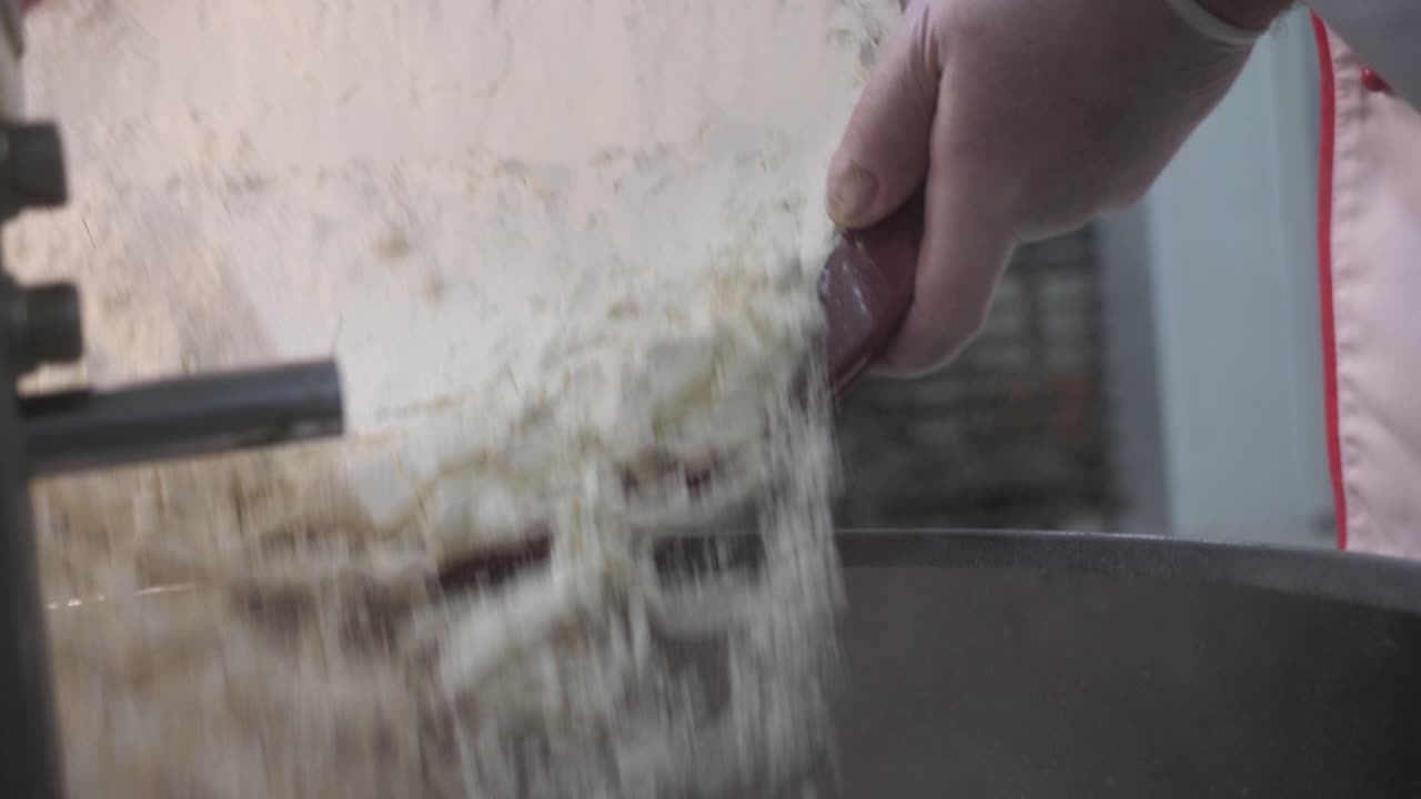 Chef adding flour to mixing bowl
