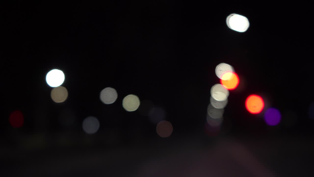 밤에 자동차와 신호등의 보케, 작은 유럽 도시의 야간 교통의 보케