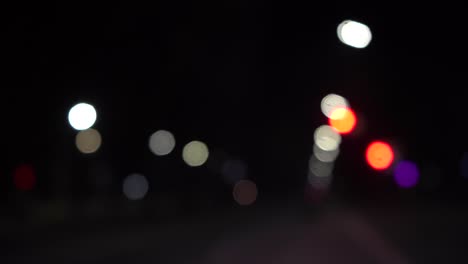 bokeh de coches y semáforos por la noche. bokeh del tráfico nocturno de una pequeña ciudad europea.