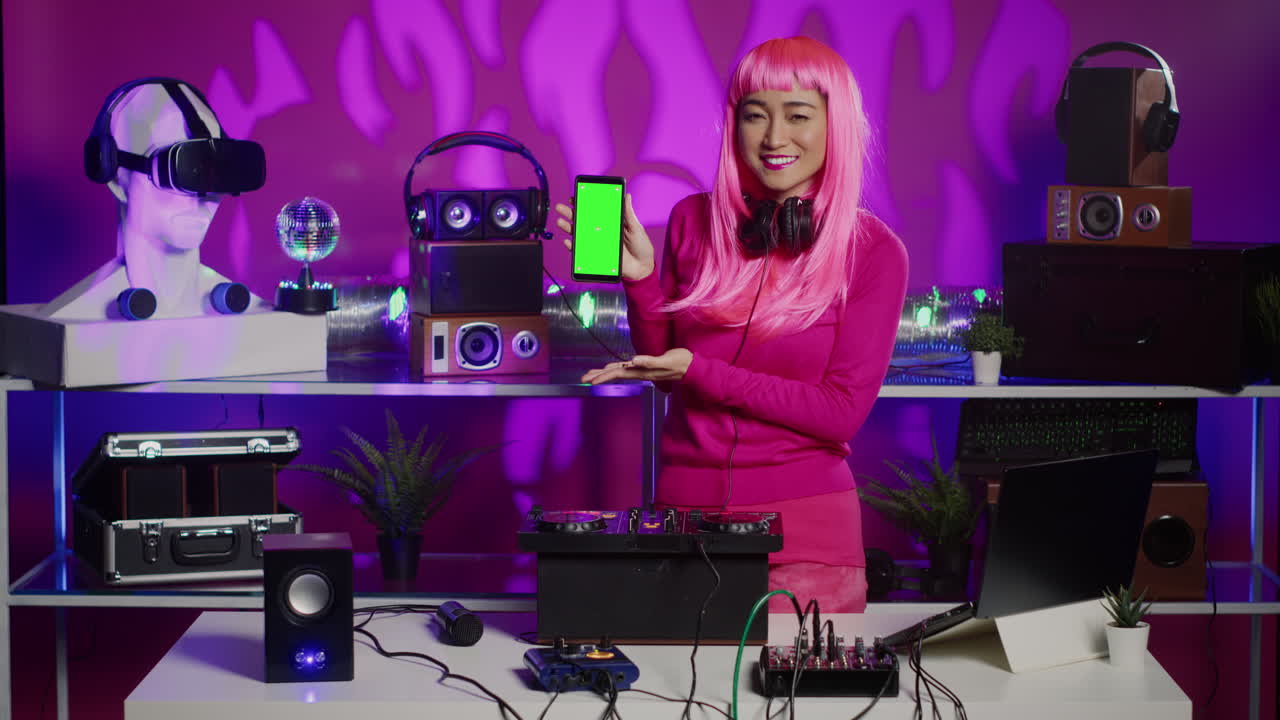 Woman DJ with Pink Hair Presenting Phone with Green Screen
