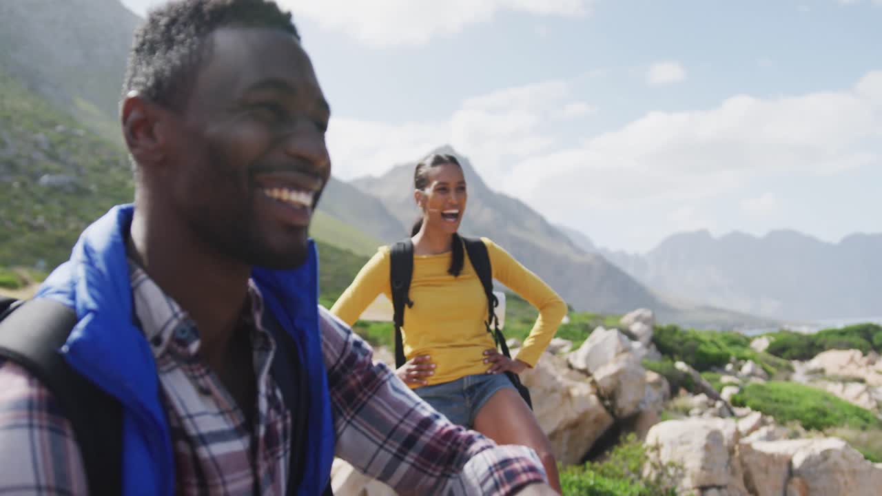 African american couple smiling and enjoying the view while hiking