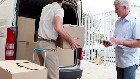 Delivery-driver-checking-his-list-on-clipboard-with-manager