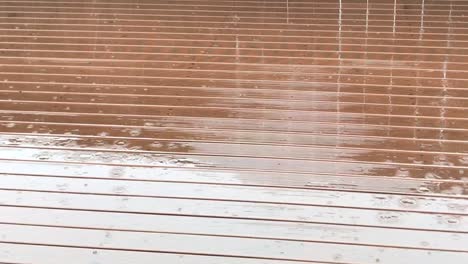 close up view of rain falling on rust stained deck during a winter day in auckland new zealand