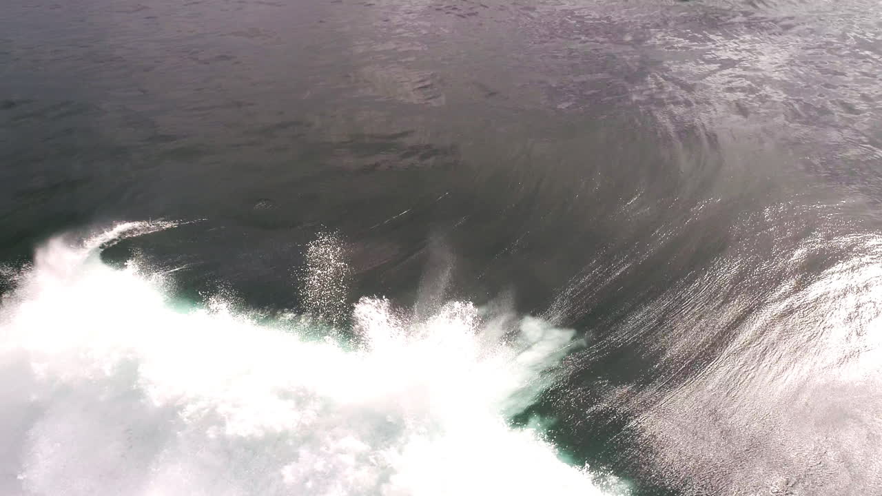 Sunrise wave curls in slow motion with glowing highlights and soft misty spray