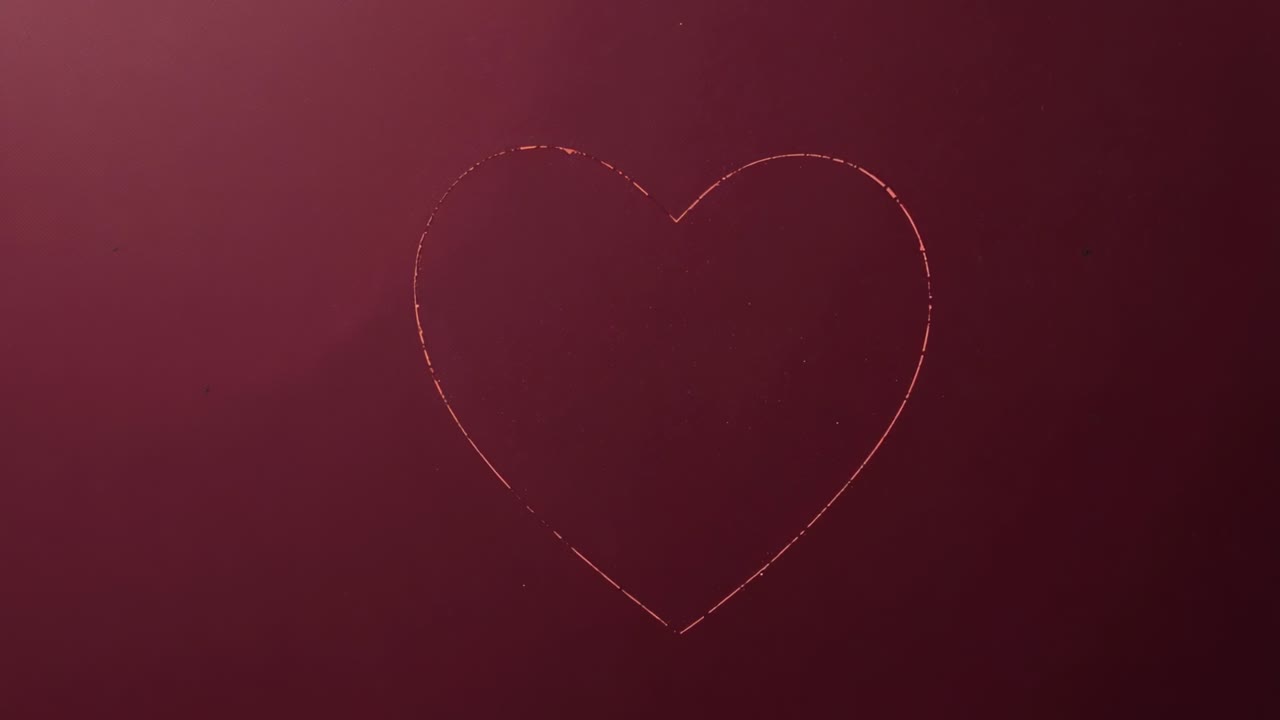 Animazione di un contorno a forma di cuore rosa pallido che si ingrandisce su uno sfondo marrone con brillantini che fluttuano, formando una linea