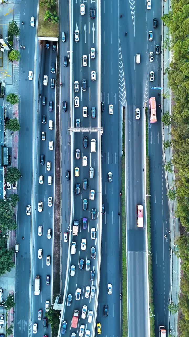 Top-down drone shot of Guangzhou, the busy streets filled with vehicles. The city’s urban layout, including dense residential and commercial areas, highlights the dynamic flow of daily life. China