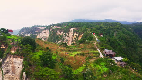 crude cottages on steep cliff above diamond beach washed by waves