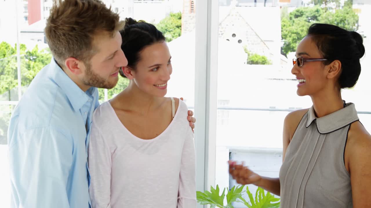 hermosa diseñadora aconsejando a una pareja linda