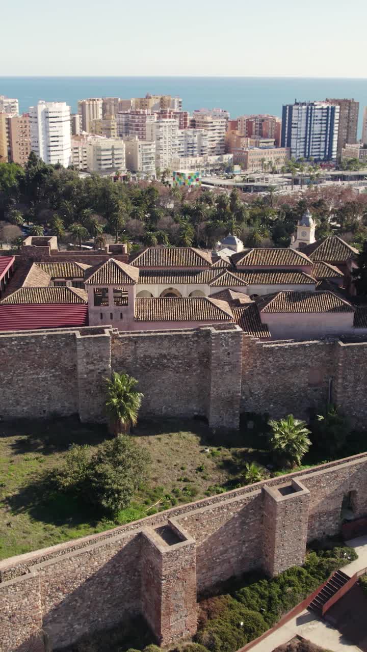 Ripresa aerea verticale a orbita che cattura le storiche mura del Castello di Gibralfaro lungo la costa mediterranea a Malaga, Spagna.