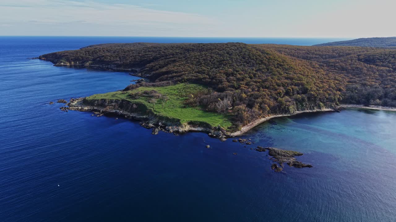Aerial view of a coastal green landscape and deep blue sea