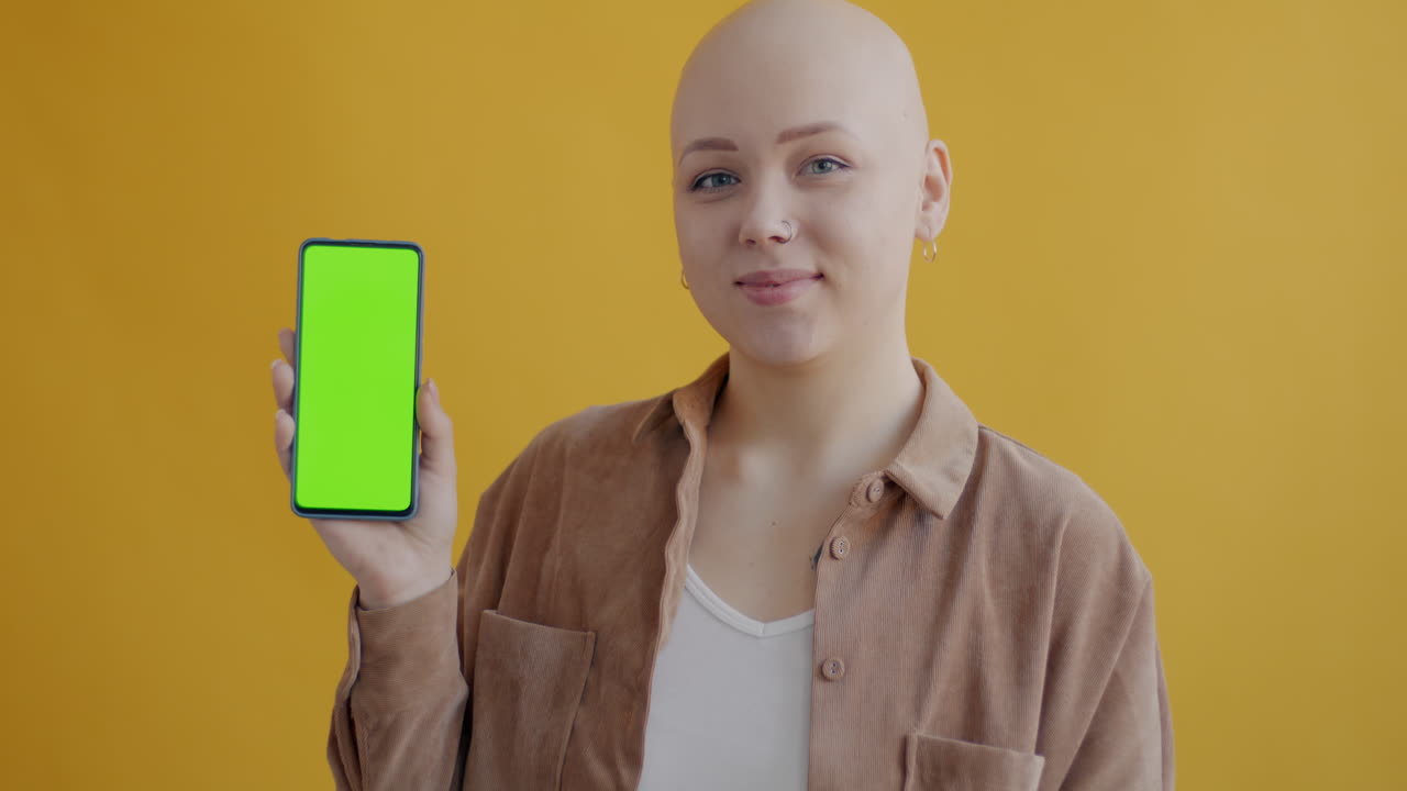 mujer sosteniendo un teléfono con pantalla verde