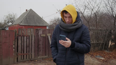 man using phone outdoors in autumn