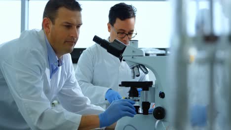 científico usando el microscopio en el laboratorio 4k