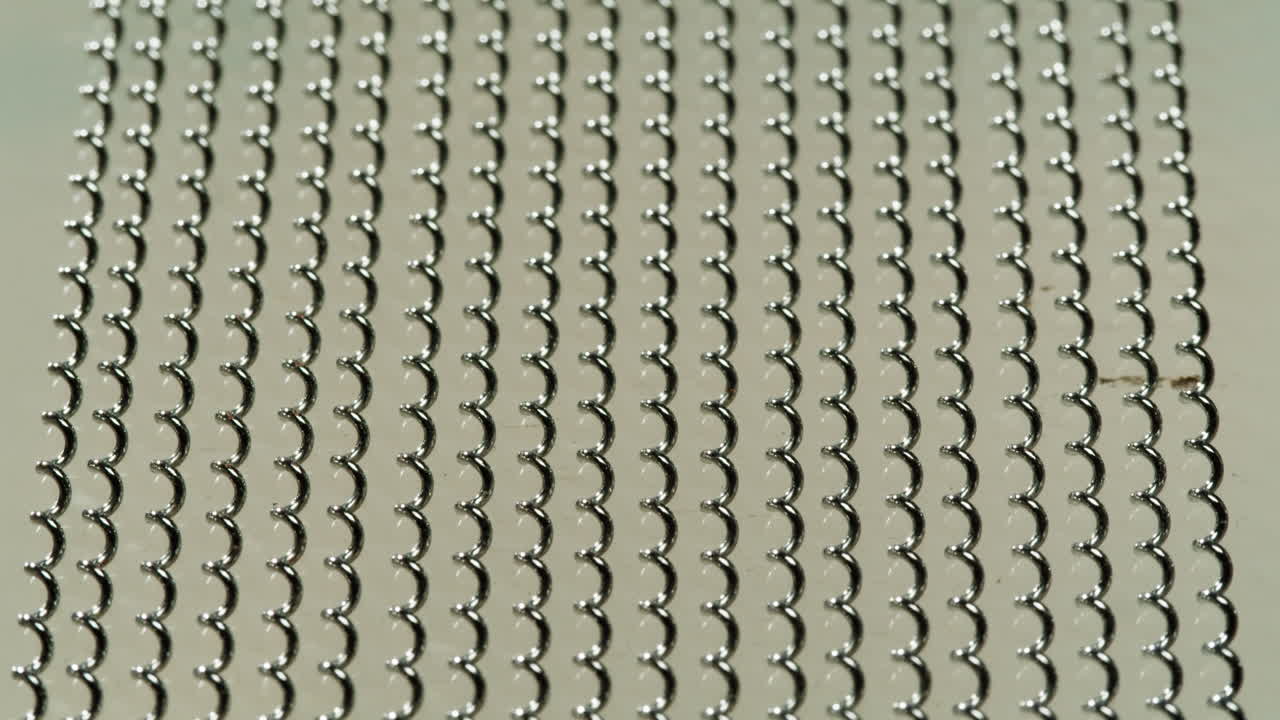 Close-up view of a metal mesh with a repeating spiral pattern