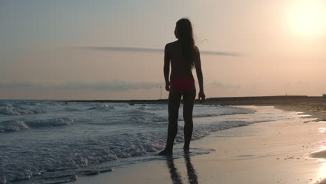 Relaxed-woman-spending-time-at-beach.-Girl-looking-at-sea-waves-at-seashore.