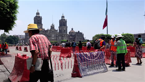 tourists visit the plaza de la constitution, constitution square, or zocalo - construction to reinforce the famous landmark