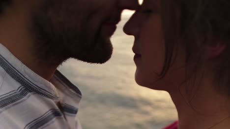 loving couple kissing on rocky cliff near sea