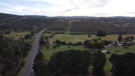 drone descending showing a major rural road in australia with a farm in the background
