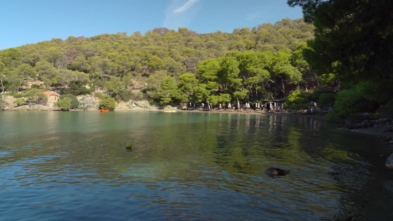 playa de la bahía del amor en la isla de poros grecia con surcos de pinos que crecen en la montaña