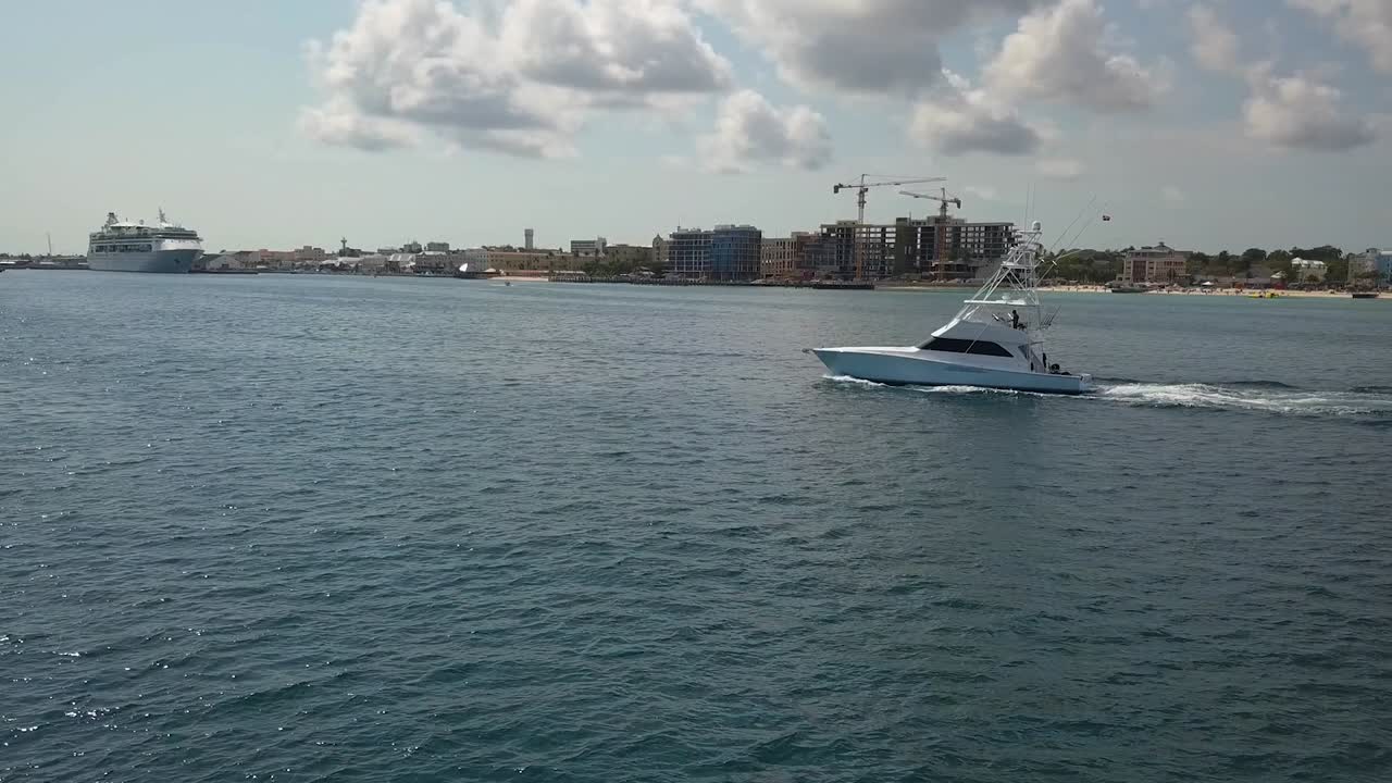 Vista aerea intorno a uno yacht che naviga lungo la costa di Nassau, Bahamas, USA - ripresa circolare con drone.