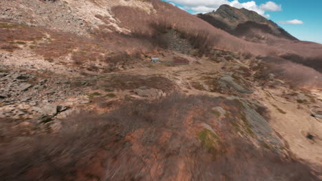 flying low over rugged mountain ridge, fpv drone captures wild, remote terrain