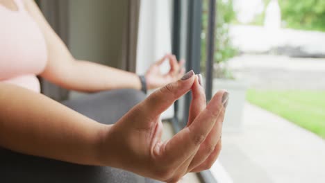 Video-De-Manos-De-Una-Mujer-Afroamericana-De-Talla-Grande-Haciendo-Ejercicio-En-Casa,-Practicando-Yoga