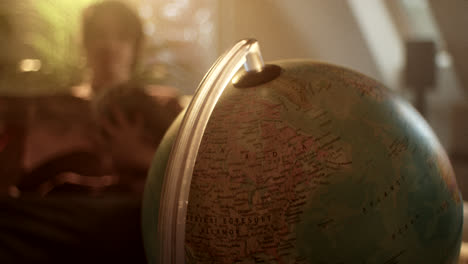 close-up of a globe with a person in the background