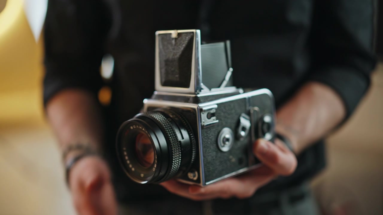 Vintage medium format film camera in man hands. Close up retro analog gear.