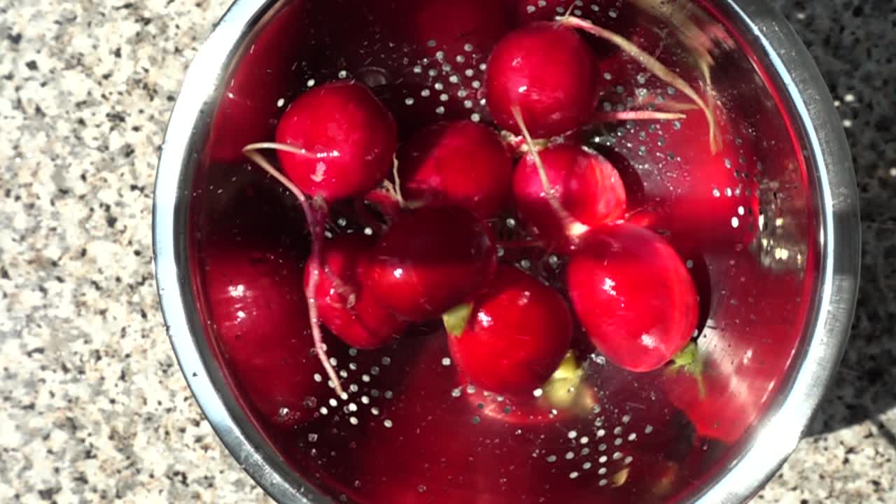 Lancer d'un radis de jardin dans une passoire. Ralenti.