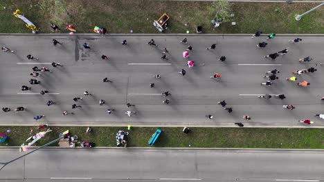 antena de arriba hacia abajo de personas que compiten en el maratón de la ciudad en la carretera principal