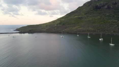 Ocean-Coastline-Aerial-Drone-View-of-yachts-,-pacific-ocean-with-rocky-mountain-on-the-background