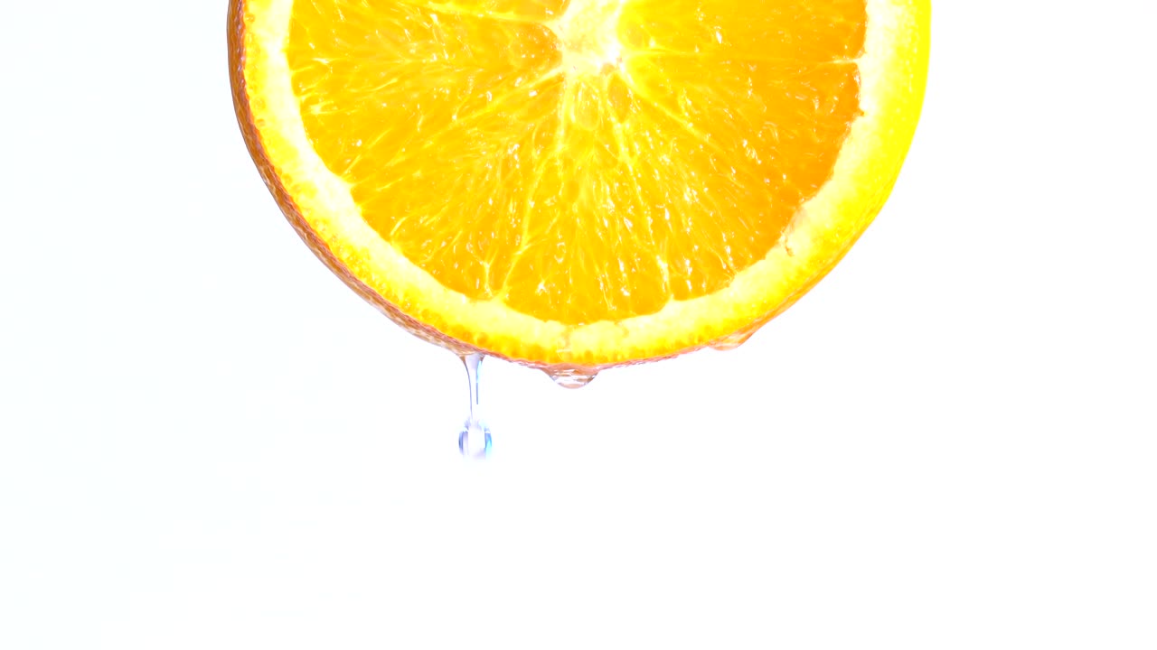 acqua o oli che cadono su una fetta di arancia, frutta per la dieta e il cibo sano