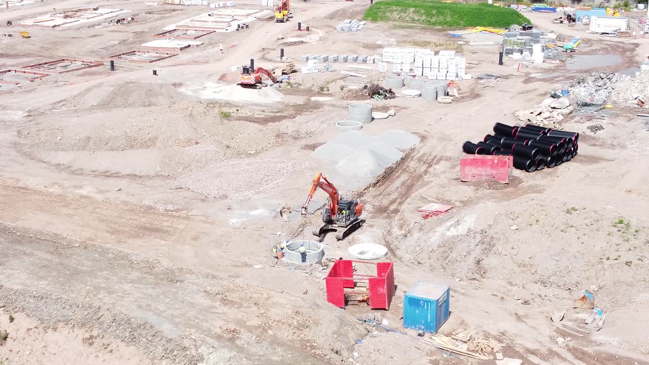 vehículo excavadora de excavación que prepara la vista aérea del tubo de hormigón en el sitio de construcción del desarrollo de viviendas en órbita a la derecha lenta