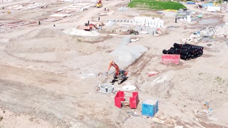 vehículo excavadora de excavación que prepara la vista aérea del tubo de hormigón en el sitio de construcción del desarrollo de viviendas en órbita a la derecha lenta