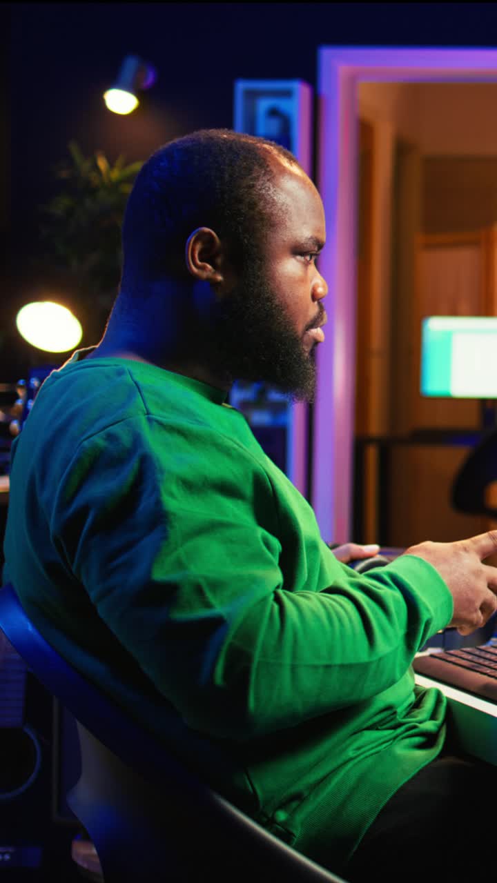 Produttore musicale afroamericano che lavora in uno studio domestico di notte