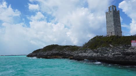 stone tower on a rocky outcrop in turquoise ocean