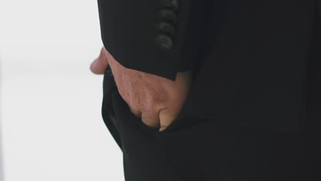 businessman-in-black-jacket-puts-hand-into-pocket-in-office